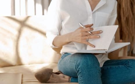 A woman in white who is practicing effective journaling